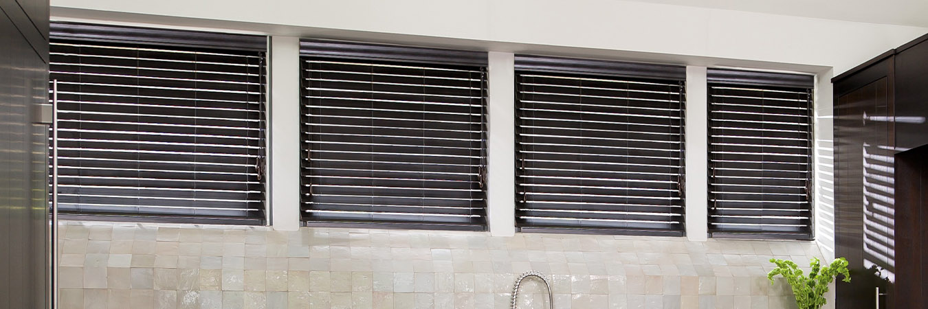 Faux wood blinds in a dark finish on kitchen windows