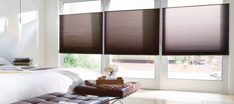 Modern Cleveland bedroom with tall windows and brown cellular shades.