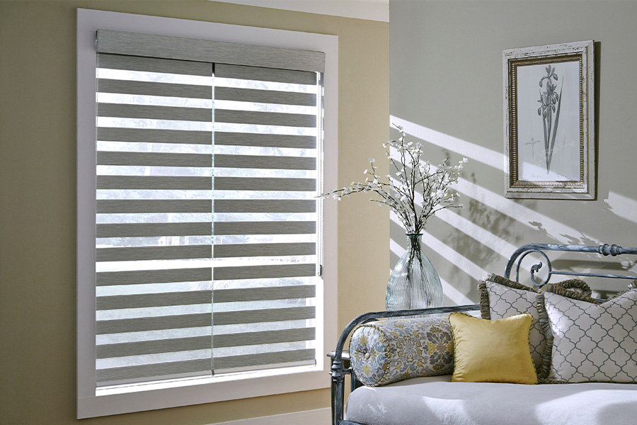 Gray blinds on a large window next to a couch.