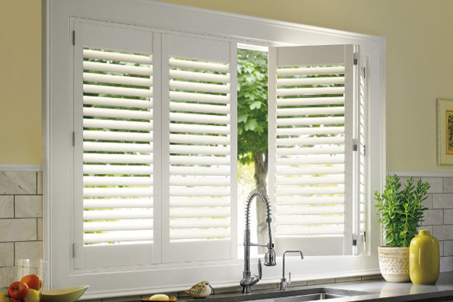 Polywood shutters are built to withstand the test of time in Cleveland. White Polywood shutters above a kitchen sink.