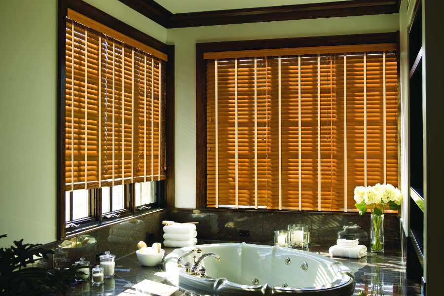 Premium quality blinds are always a stylish accent in your Cleveland home. Brown wood blinds on large windows in a green bathroom