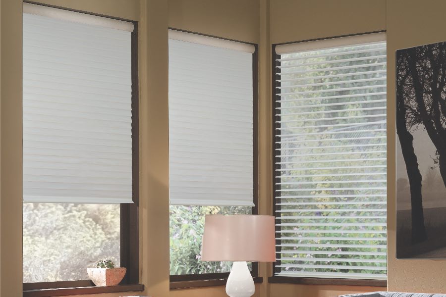 Opaque motorized window shades in Cleveland keep hot UV rays out of your home. Gray motorized sheer shades on corner windows next to gray furniture