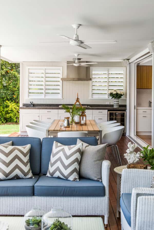 Utilize Polywood shutters for your outdoor living spaces. Large patio with outdoor kitchen, sitting area, and dining area. Two separate white Polywood shutter windows are located above the kitchen counter.