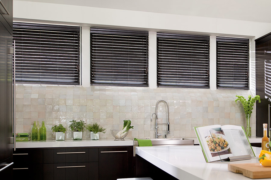 Choose custom Polywood faux wood blinds for your kitchen in Cleveland. Special shaped faux wood blinds in several windows above a sink.