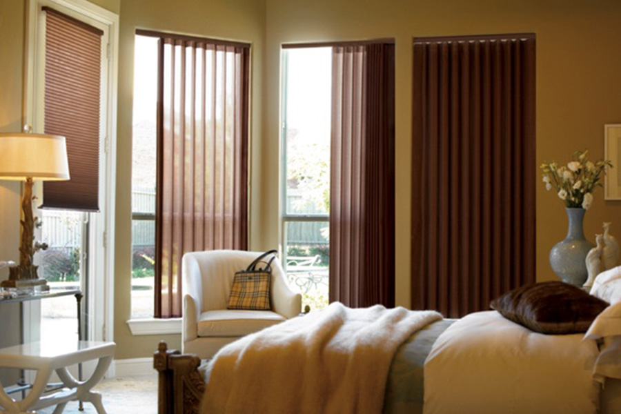 Choose durable and high-quality fabric or vinyl vertical blinds in Cleveland. Maroon fabric vertical blinds inside a bedroom