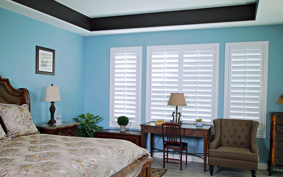 Polywood shutters provide insulation for the perfect temperature all year long in Cleveland. Polywood shutters in a bedroom.