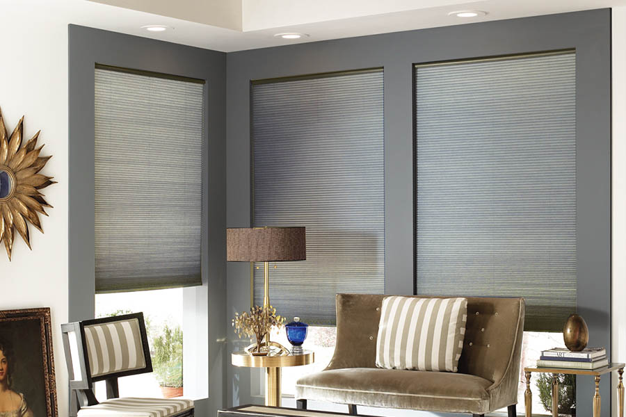 Add style and comfort to your home with cellular shades in Cleveland. Gray cellular shades in a corner of a stylish living room.